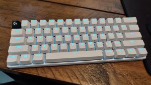 The Logitech Pro X60 keyboard, lit up in blue, on a wooden desk
